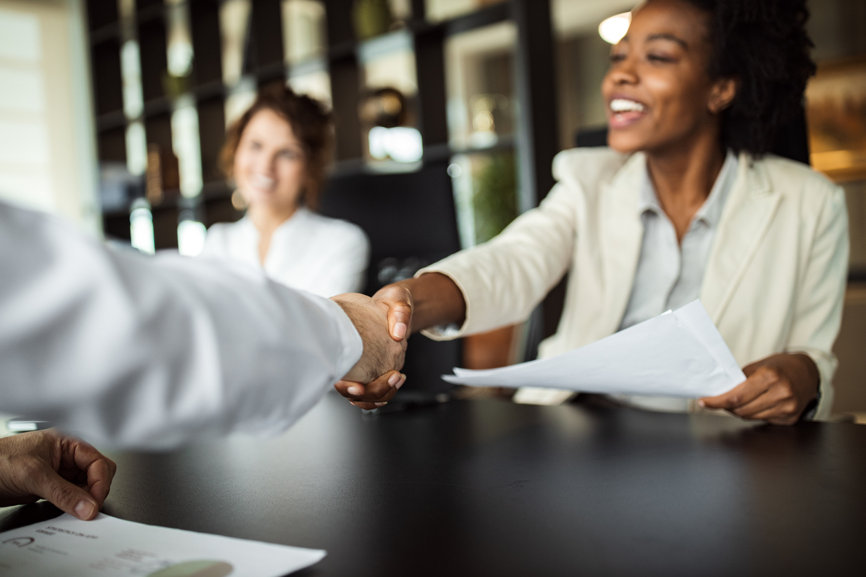 African American Business woman making plans with somebody, shaking hands. New Hire.