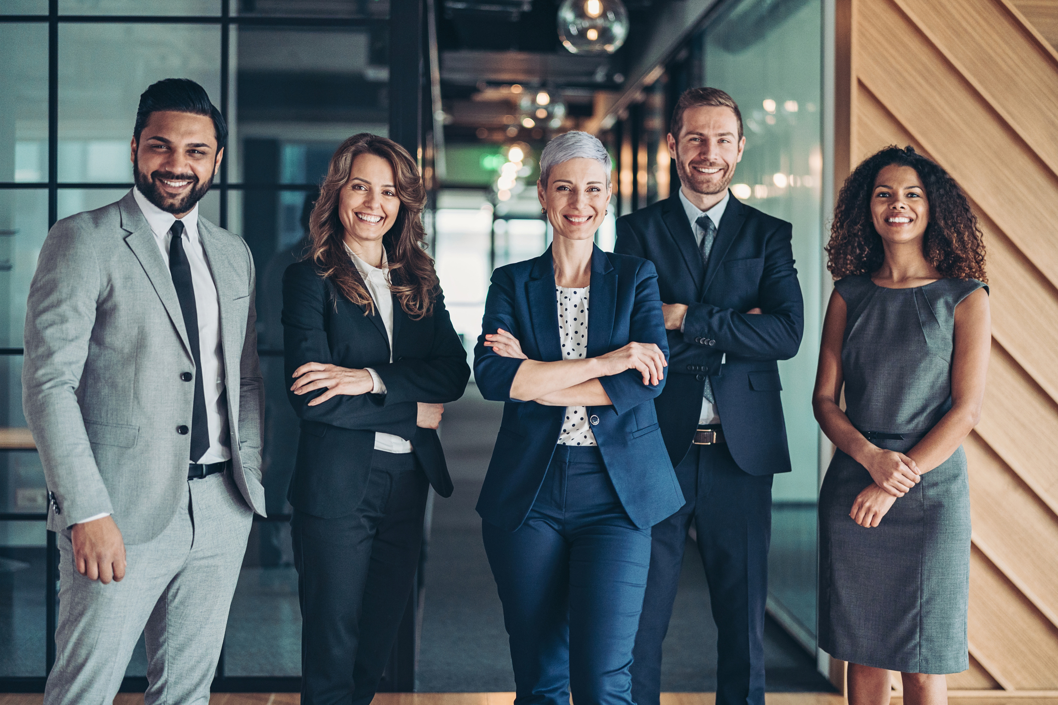 A multi-ethnic team of Leadership professionals standing together. Representing a supportive and empowering attitude.