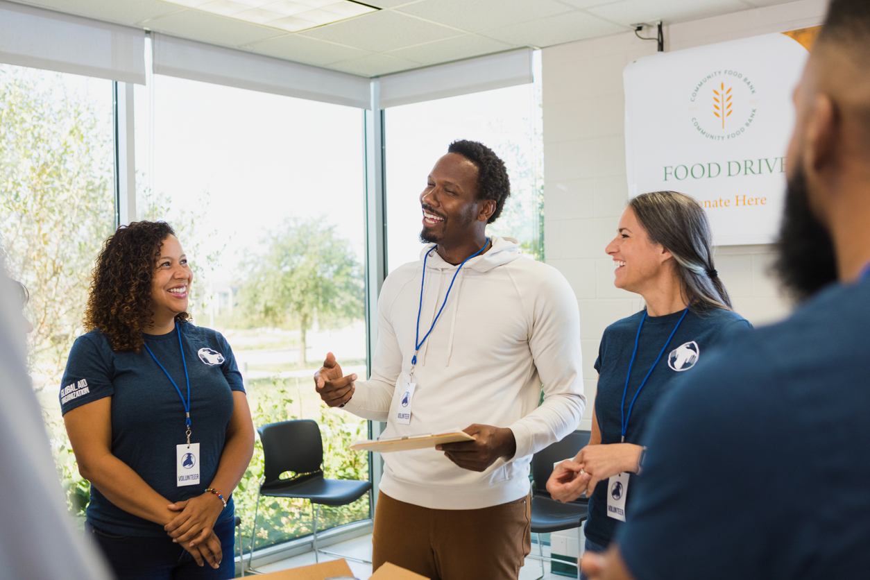 Volunteers smile as they listen to leadership.