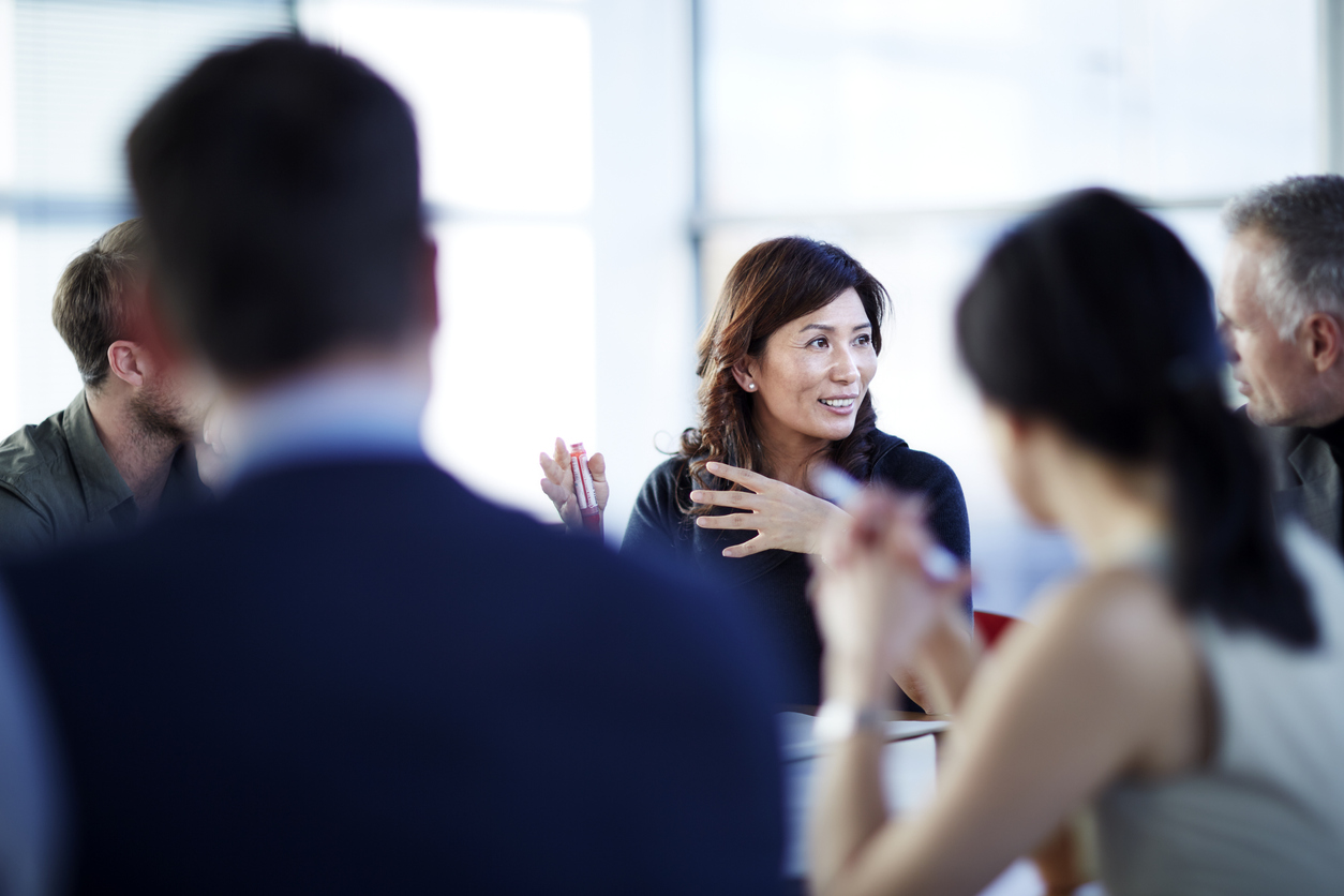 Business people talking and collaborating in meeting.