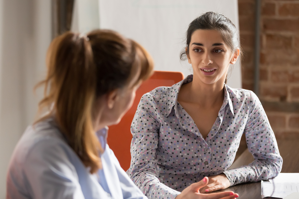 Businesswoman speaking to a client at business office meeting.