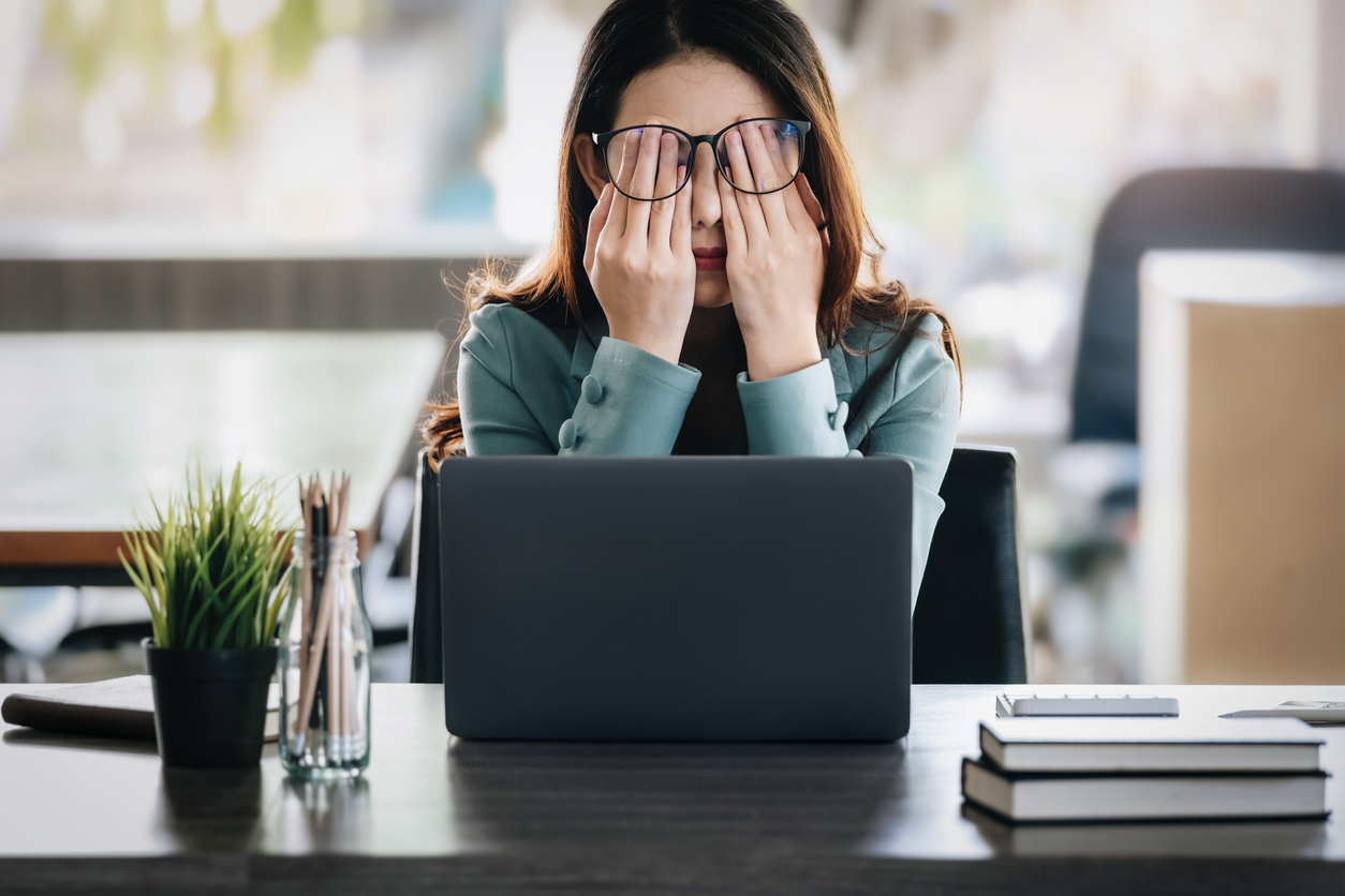 Business Woman with hands over face, stressed out.