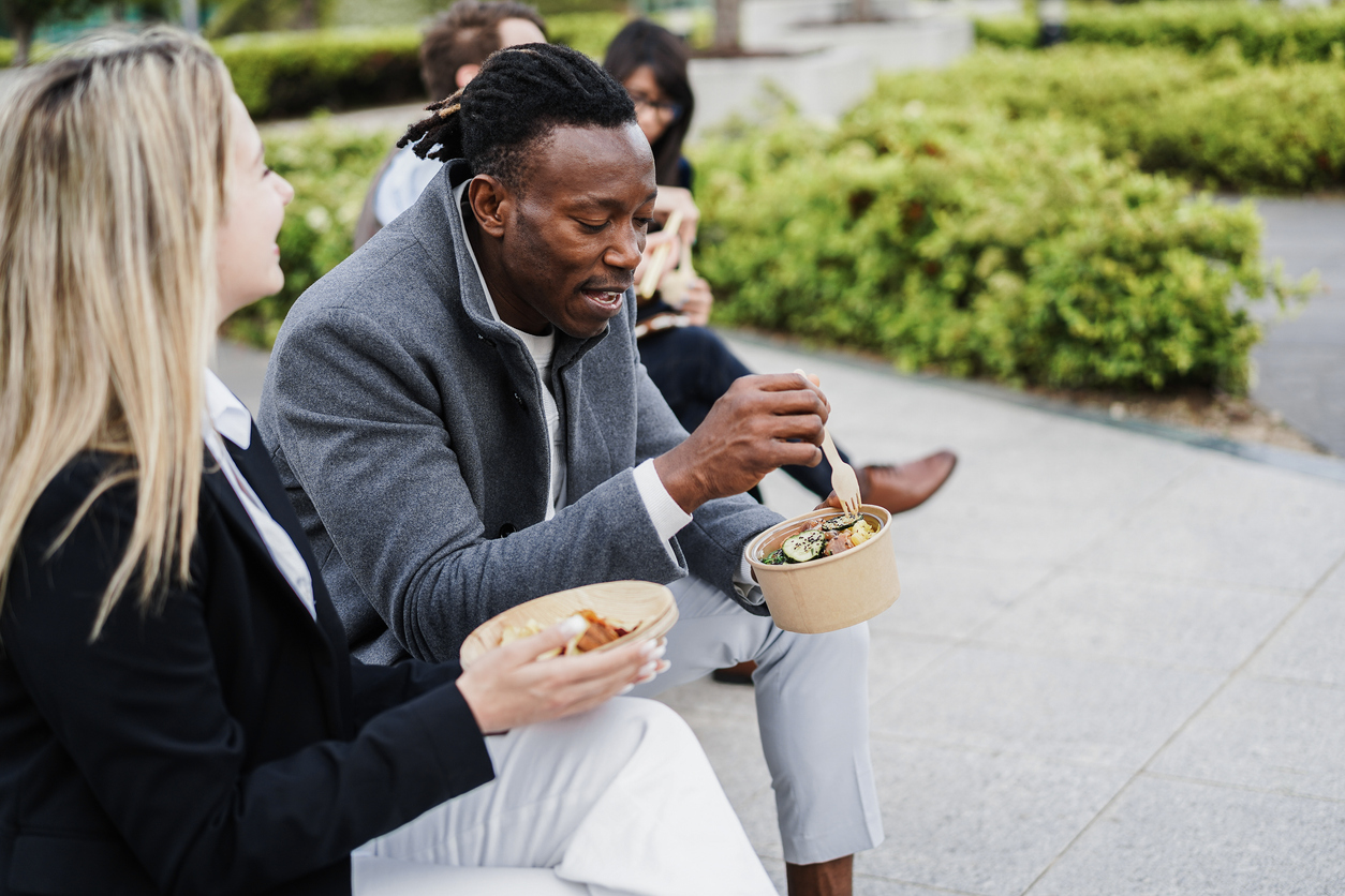 Multiethnic business people doing lunch break outdoor from office building.