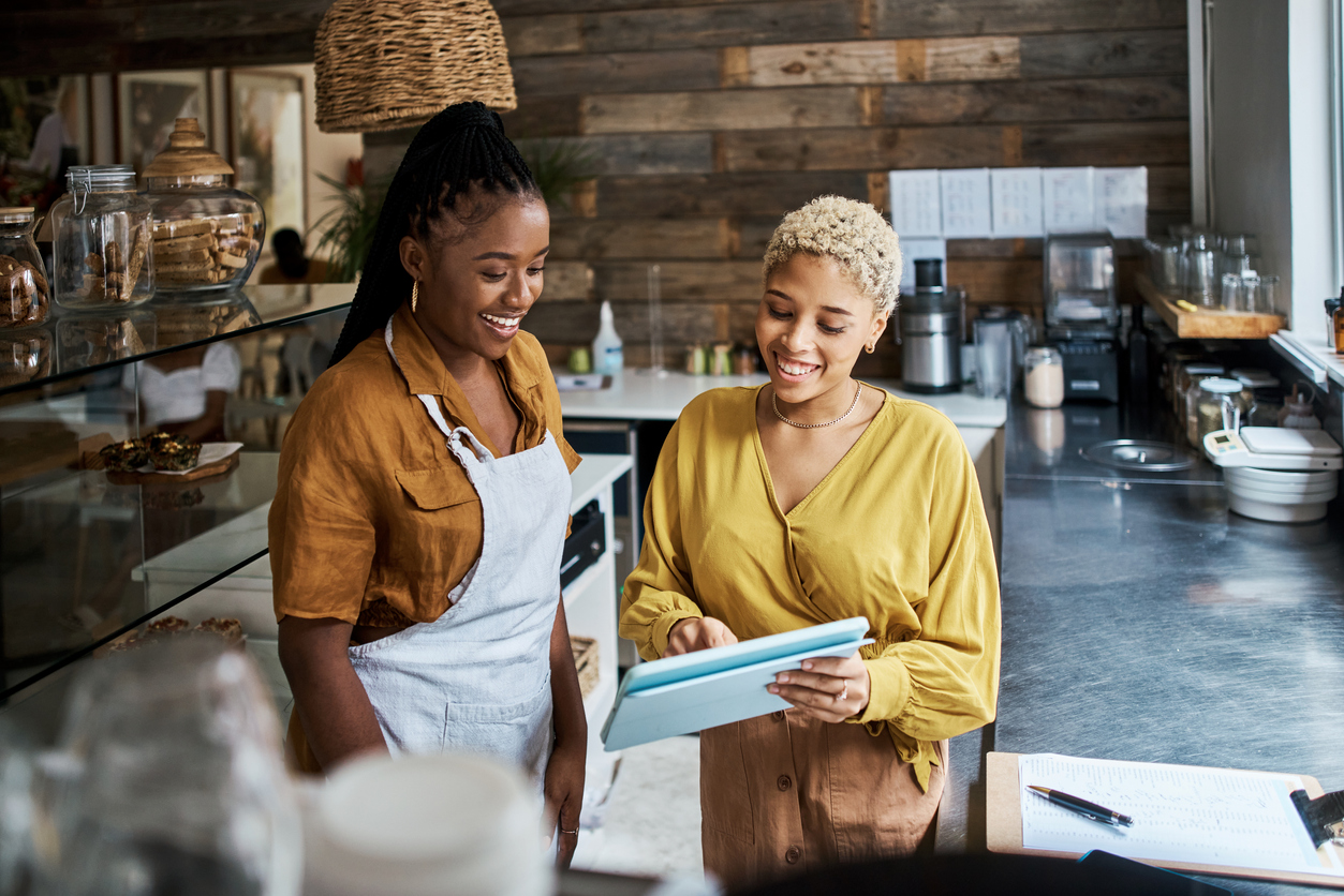 Coffee shop manager and employee smiling.