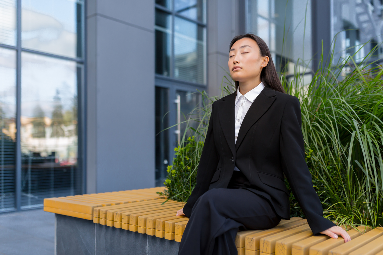business woman sitting on a bench relaxing, meditating.