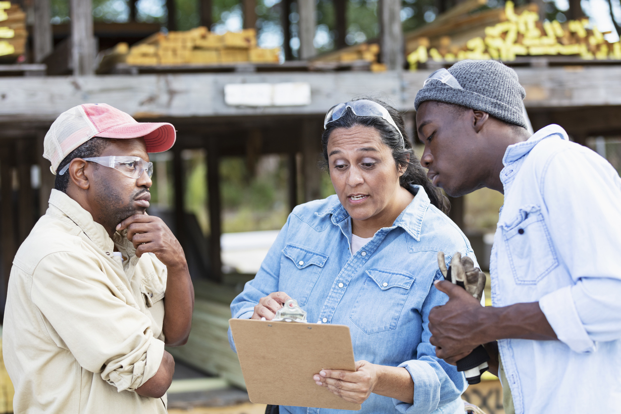 A multiracial group of three people having a meeting.