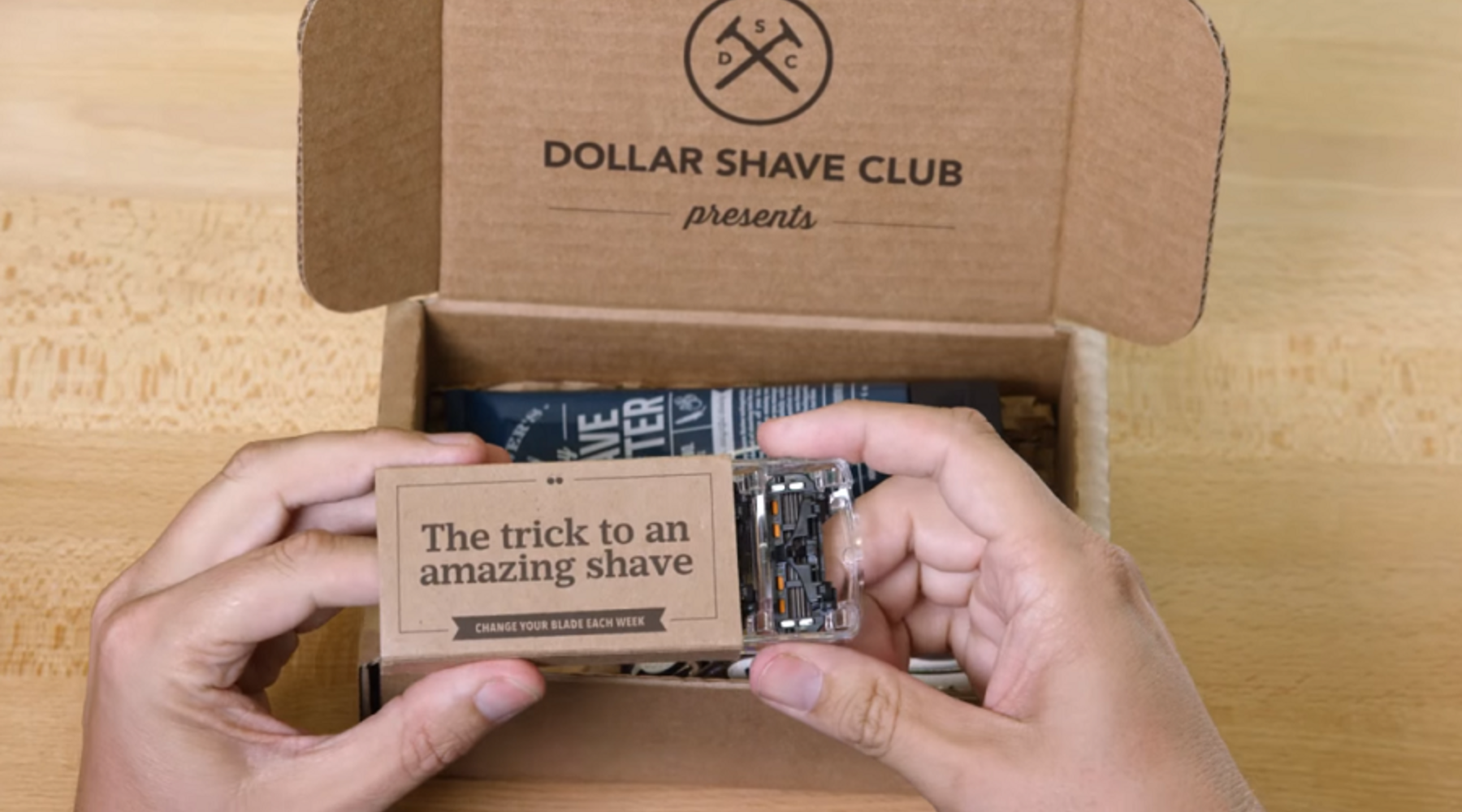 Dollar Shave Club- Hands holding DSC razors.