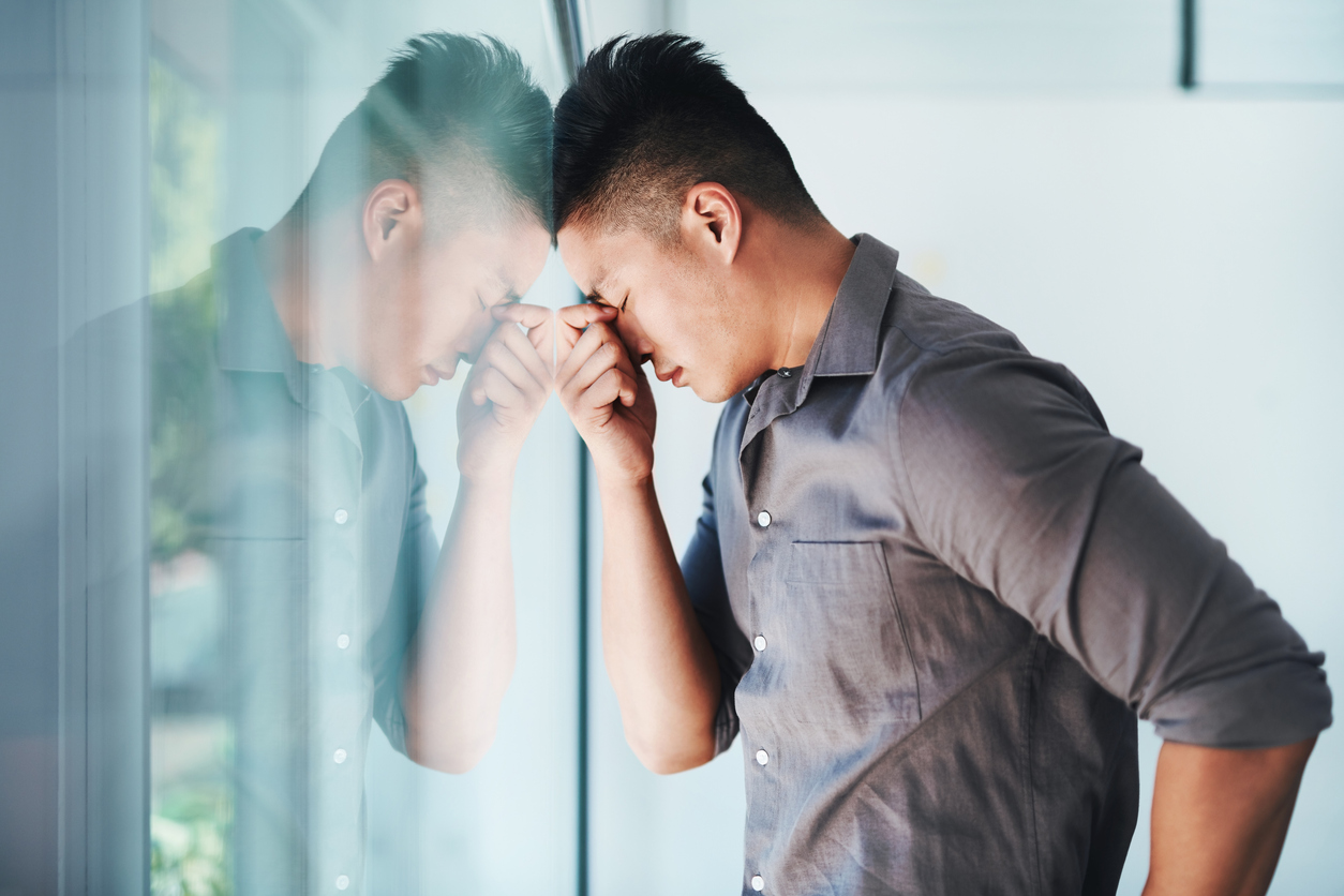 Shot of a young businessman looking stressed out in an office.