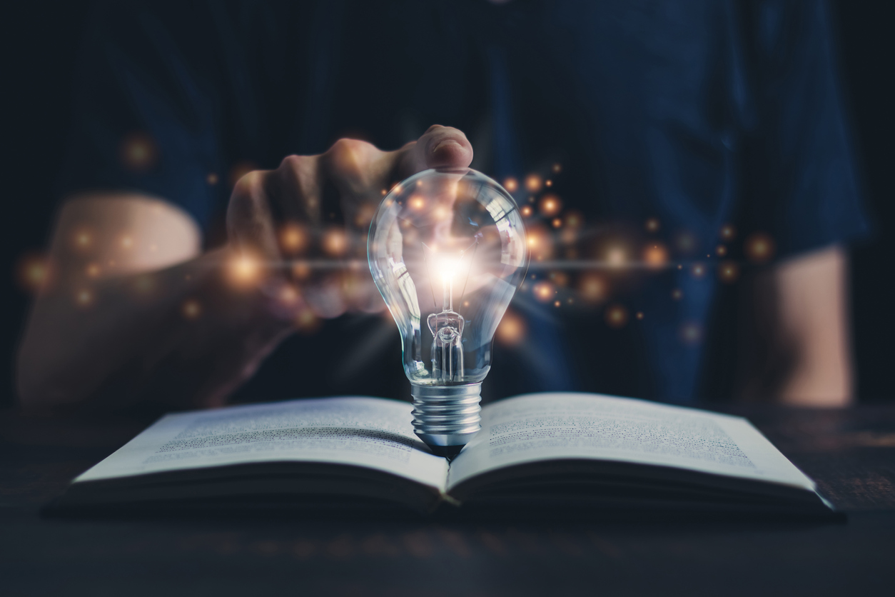 Glowing light bulb and book or text book with futuristic icon. Self learning or education knowledge and business studying concept. Idea of learning.